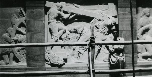 Lyndon Dadswell standing beside the Sanctuary frieze panel depicting Engineers and Tunnellers c1931-1932 photographer Victor Hawley Wager Shrine of Remembrance Collection