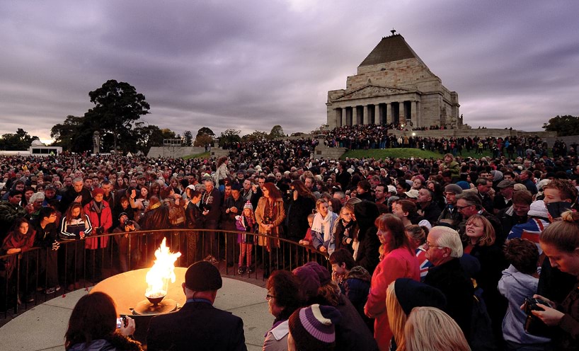 A large crowd gather around the Eternal Flame for the Shrine of Remembrance Anzac Day Dawn Service