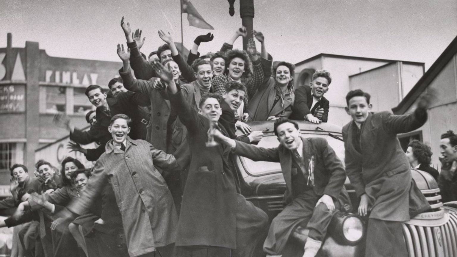 Crowd of women and boys on factory trucks in Elizabeth Street on VP Day 1945. Reproduced courtesy of State Library Victoria H98.101/304 Black and white photograph of a crowd of women and boys celebrating on factory trucks in Elizabeth Street during VP Day 1945