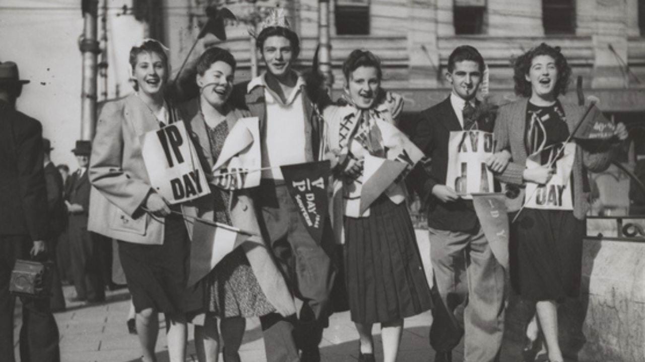 Group of unidentified civilian men and women celebrating in the streets of Perth on VP Day 1945