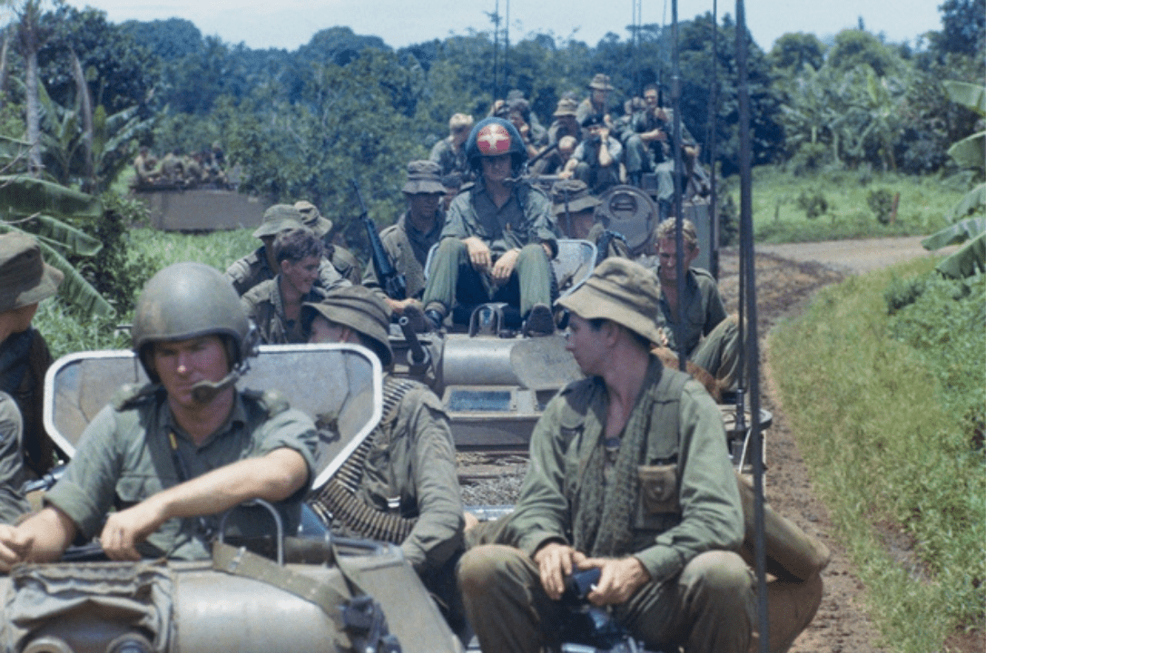 Soldiers of 6RAR/NZ (ANZAC) aboard armoured personnel carriers returning to Long Tan to set up a memorial cross and hold a commemorative service at the battle site.